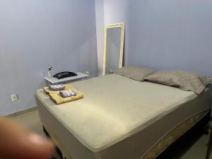 a bed with a mirror and a towel on it at Apto 1 Central em Fátima do Sul térreo in Fatima do Sul