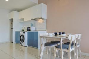 a kitchen with a table and chairs and a microwave at Greystone Continew Residensi in Kuala Lumpur