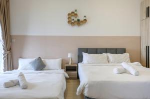 two beds in a room with white sheets and pillows at Greystone Continew Residensi in Kuala Lumpur