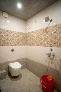 bagno con servizi igienici e sgabello rosso di The Pleasure Stay a Varanasi Altre 24 foto