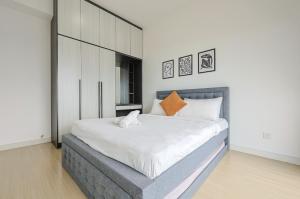 a bedroom with a large bed with white sheets and orange pillows at Greystone Continew Residensi in Kuala Lumpur