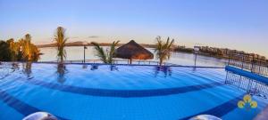 a large blue swimming pool with a beach in the background at Resort do LAGO - Caldas Novas in Caldas Novas