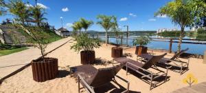 a group of chairs and trees on a beach at Resort do LAGO - Caldas Novas in Caldas Novas