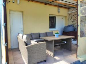 a patio with a table and chairs and a couch at Aminyaralónk in Balatonmáriafürdő
