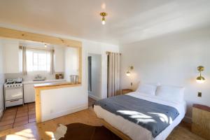 a bedroom with a large bed and a kitchen at Alamo Motel in Los Alamos