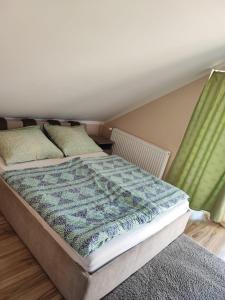 a bedroom with a bed with a quilt on it at Aminyaralónk in Balatonmáriafürdő