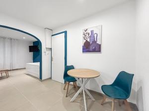 a room with a table and blue chairs at Suite Erastis Avec Spa Privé in Épinal