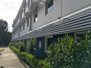 ein Gebäude mit einer Reihe von Fenstern und Pflanzen in der Unterkunft ibis Budget - Gosford in Gosford