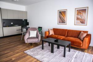 a living room with a couch and a chair at Rigeli Apartments in Kosovo Polje