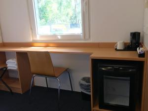 a kitchen with a stove and a microwave at ibis Budget - Gosford in Gosford