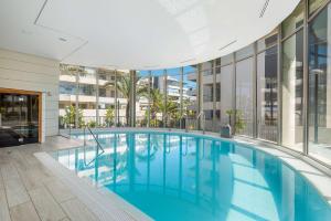 a large swimming pool in a building with windows at La Zenia Cocoon Lux Penthouse in Dehesa de Campoamor