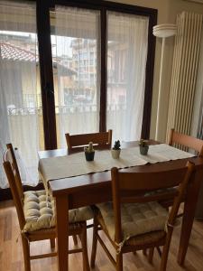 a dining room table with chairs and a large window at Like Home mono 2 in Sesto Calende +10 photos