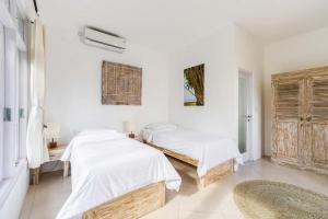 two beds in a room with white walls at Mondo Surf Village in Canggu +9 photos