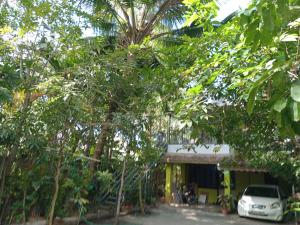 a car parked in front of a building with trees at Greens Homestay Varkala in Varkala