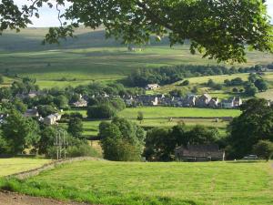 a village in the middle of a green field at Old Coach House At The Golden Lion in Saint Johns Chapel