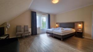 a hotel room with a bed and a large window at Hotel Tini in Bad Fallingbostel