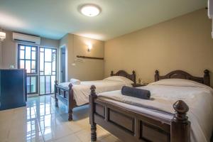 a bedroom with two beds and a large window at Mali's Room in Chiang Mai