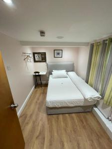 a bedroom with a bed and a desk in it at Leman House in London +22 photos