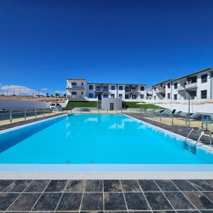 een groot zwembad met gebouwen op de achtergrond bij La Preciosa Suite Apartment in Antigua