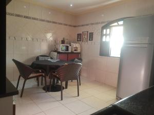 a kitchen with a table and chairs and a refrigerator at Sobrado estilo Colonial in Salvador