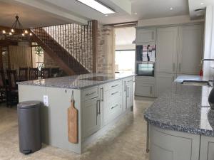 a kitchen with white cabinets and granite counter tops at La Maison du Parc 47 in Fumel