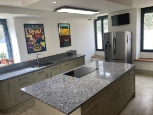 a kitchen with granite counter tops and a refrigerator at La Maison du Parc 47 in Fumel