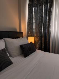 a white bed with two pillows in a bedroom at HERA QUEEN Boutique in Larisa