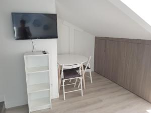 een kamer met een tafel en een tv aan de muur bij Centre de Nice : Studio rénové, climatisé et calme in Nice
