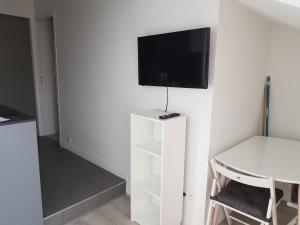 een woonkamer met een tv aan een witte muur bij Centre de Nice : Studio rénové, climatisé et calme in Nice