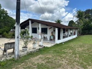 a small white house with a grass yard at Chácara Mirage in Camaragibe