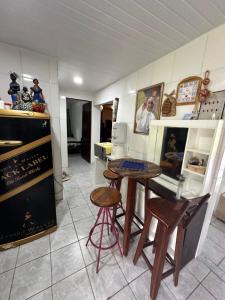 a kitchen with a table and two stools at Chácara Mirage in Camaragibe