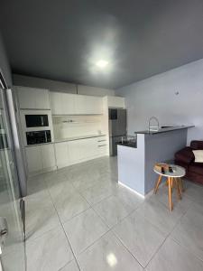 una grande cucina con armadi bianchi e tavolo di Recanto Salinas - Casa alto padrão a 350mts da praia a Balneário Barra do Sul