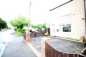 a building with a fence next to a street at Whitley Bay - Sleeps 6 - Dogs welcome in Whitley Bay
