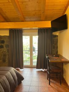 a bedroom with a bed and a desk and a window at Villa Casina dell'Etna in Ragalna