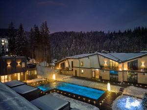 布克维Twins Hotel & Spa的晚上有游泳池的房子