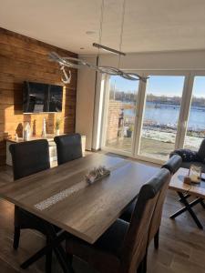 a dining room table with chairs and a large window at NEU! Ferienhaus Schöne Aussicht direkte Strandlage in Aurich