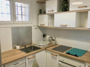a kitchen with white cabinets and a sink at Studio vue mer in Sausset-les-Pins