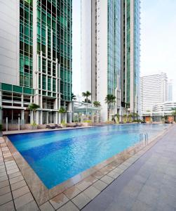 ein Schwimmbad in einer Stadt mit hohen Gebäuden in der Unterkunft Fraser Residence Sudirman Jakarta in Jakarta