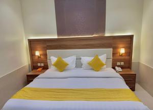 a bedroom with a large white bed with yellow pillows at توارن للشقق المخدومة الاقتصادية in Riyadh +29 photos