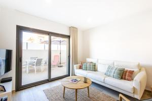 a living room with a white couch and a table at Baia Mar T1 - By Smarthomes in São Martinho do Porto
