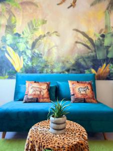 Sofá azul en una habitación con mesa en L'Oasis urbaine, en Le Mans