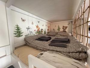 a bedroom with a large bed withanimal themed walls at Apartmán Šumavský skřítek in Čachrov