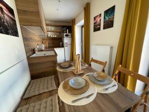 a small kitchen with a wooden table and chairs at Apartmán Šumavský skřítek in Čachrov