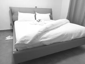 un letto con lenzuola bianche e un fiore sopra di Mama's Favourite ltd a Kigali Altre 2 foto