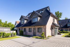 a brick house with a black roof at Ferienhaus Küstenglück Zingst in Zingst