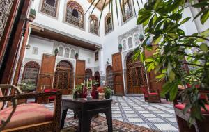 a room with a table and chairs in a building at Riad - Dar Al Andalous in Fès