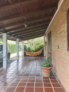 a patio with a hammock on a house at Pepa Kingdom in Matinhos