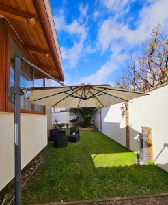 a patio with an umbrella in the grass at Oasi di Greta Suite Home - Fiumicino in Fiumicino
