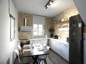 a kitchen with a table and a black refrigerator at Angelica Residence - Perfect Quiet Center Location - 10mins Walk to Gennadi Beach in Gennadi