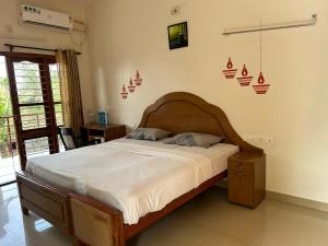 a bedroom with a bed with a wooden head board at Mattuppavu Beach House in Vilinjam